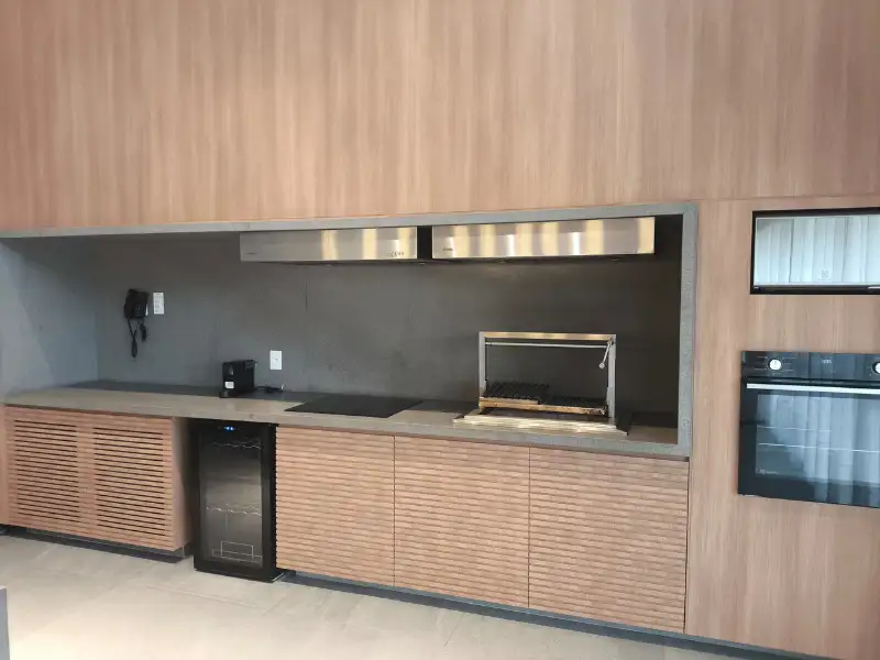 Duas coifas de embutir em inox instaladas em armário planejado de madeira clara